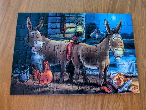 A small jigsaw puzzle showing two cartoon donkeys, holding a hot water bottle between their rumps.