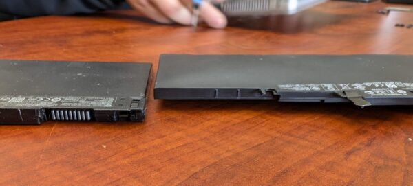 A picture of two laptop batteries side by side, one very puffy. 